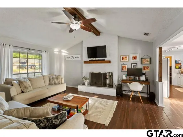 a living room with furniture a fireplace and a flat screen tv