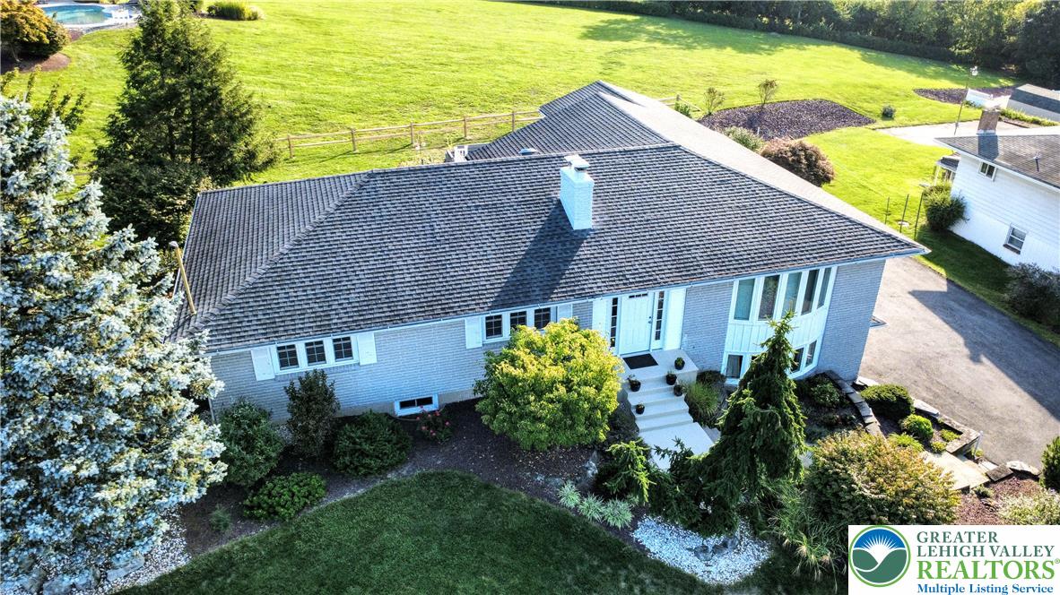 3285 Cherryville Road Northampton, PA 18067 - Photo 1 of 51 An aerial perspective showcases a classic brick ranch home nestled among mature landscaping.