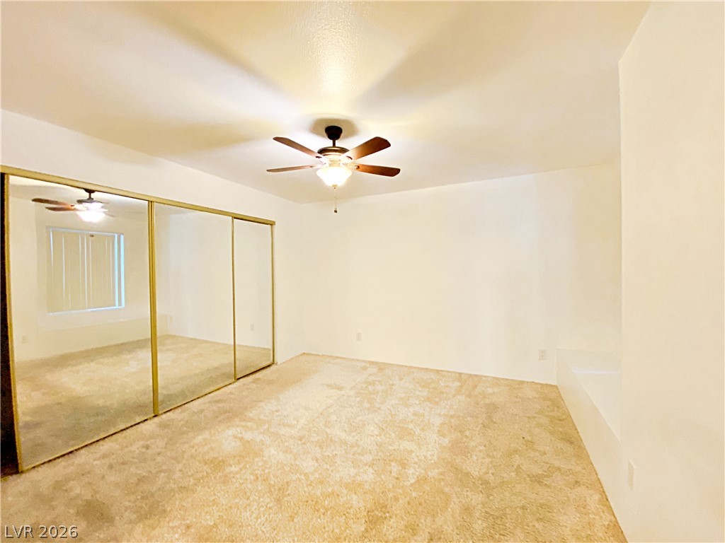3145 East Flamingo Road, Unit 1128 Las Vegas, NV 89121 - Photo 13 of 19 A spacious bedroom featuring mirrored closet doors and a ceiling fan for optimal comfort.