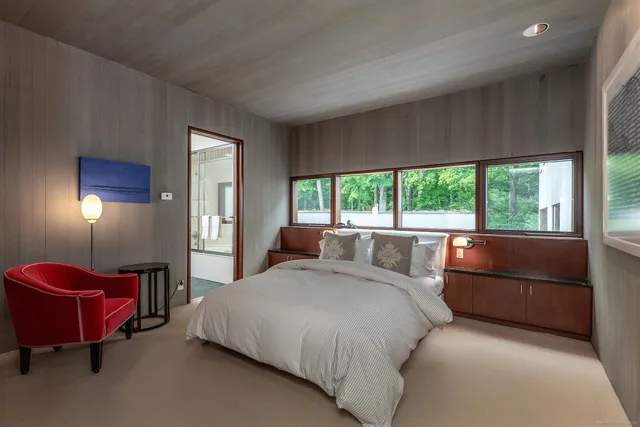 a bed room with a bed and a chair