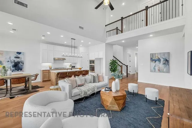 a living room with furniture kitchen view and a chandelier
