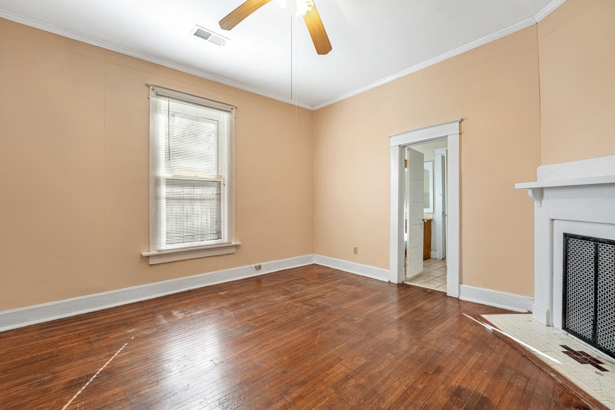 1033 Bruce Street Memphis, TN 38104 - Photo 8 of 19 an empty room with windows fireplace and wooden floor