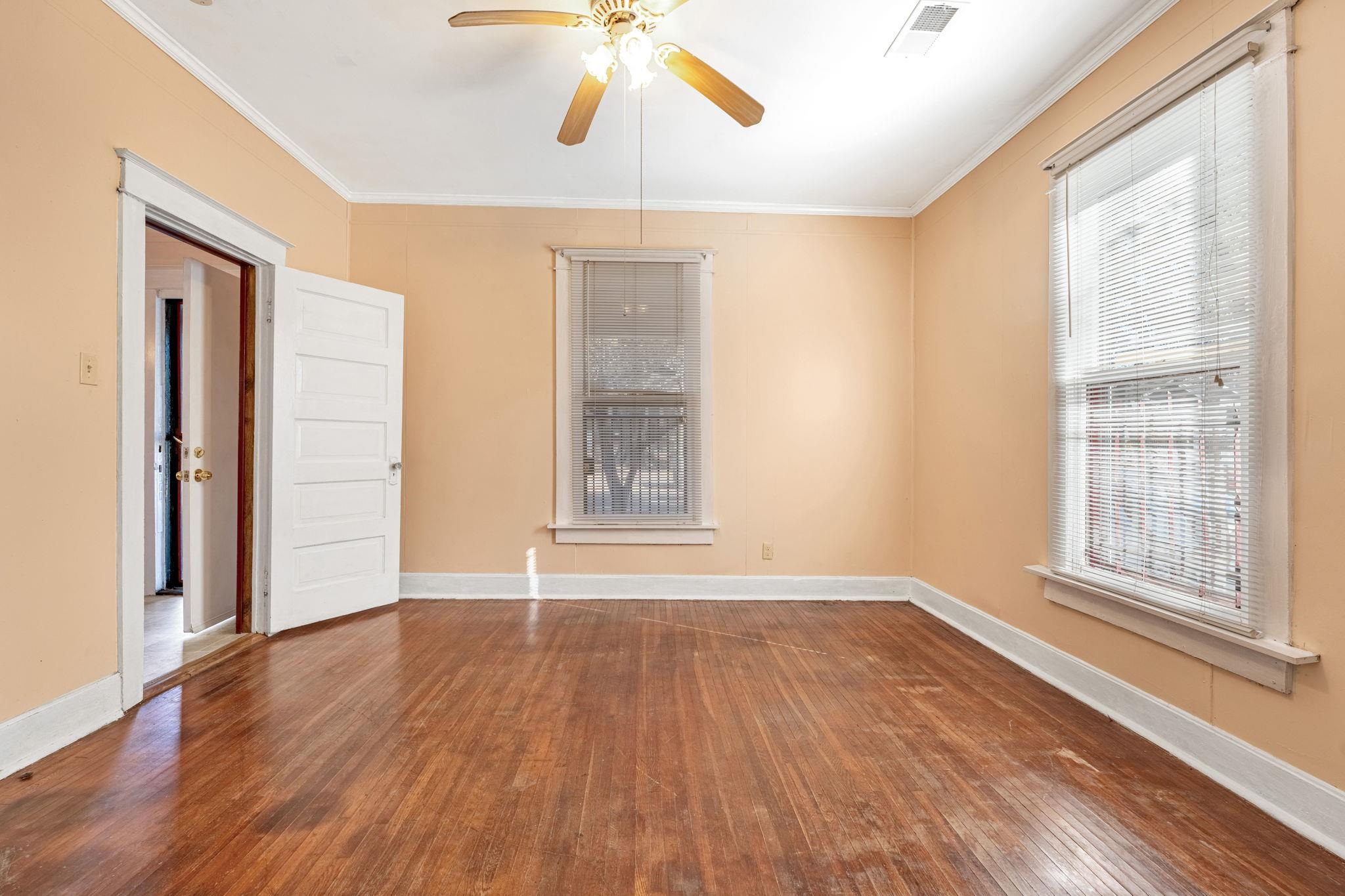 1033 Bruce Street Memphis, TN 38104 - Photo 9 of 19 an empty room with wooden floor and windows