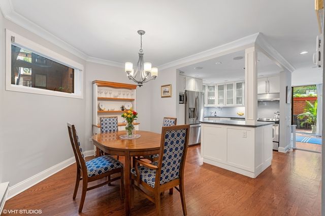 a view of a dining room with furniture a chandelier and wooden floor