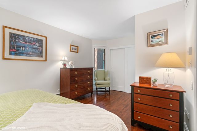 a bedroom with a bed and a lamp on dresser