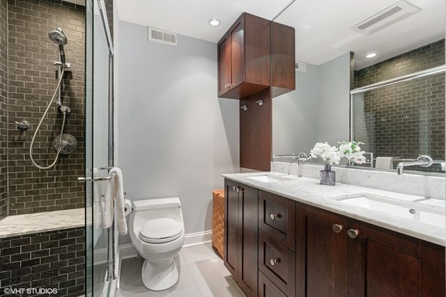 a bathroom with a granite countertop sink toilet and shower