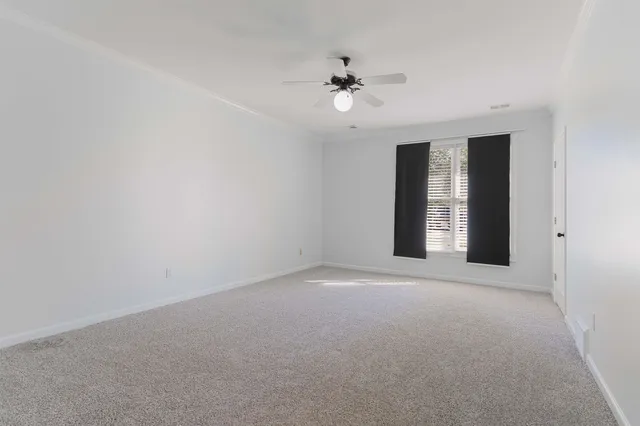 a view of an empty room with a chandelier fan