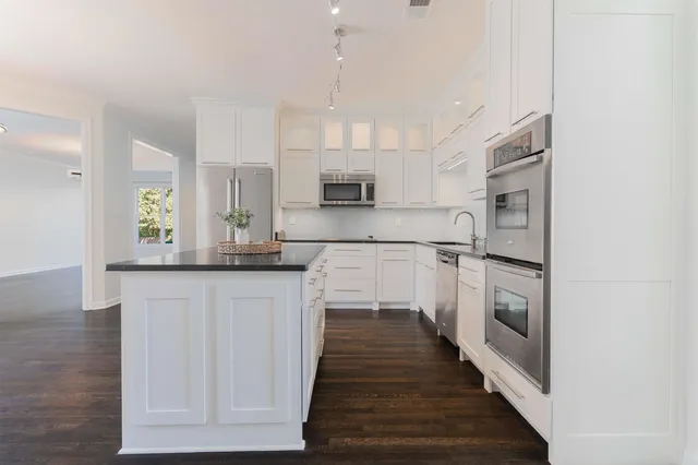 a kitchen with stainless steel appliances granite countertop a stove a sink and a refrigerator
