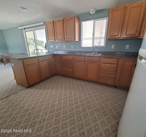 a kitchen with granite countertop a sink window and cabinets