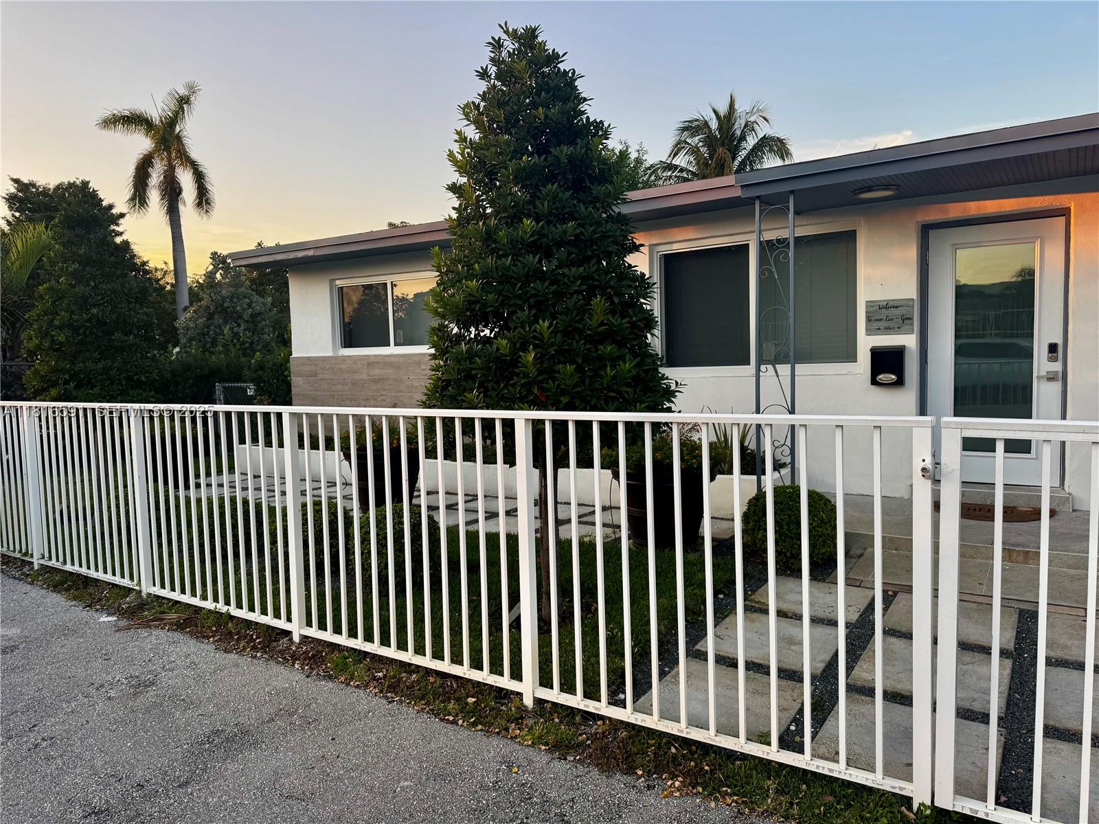 1012 Southwest 3rd Avenue Hallandale Beach, FL 33009 - Photo 2 of 35 a side view of a house with a small yard