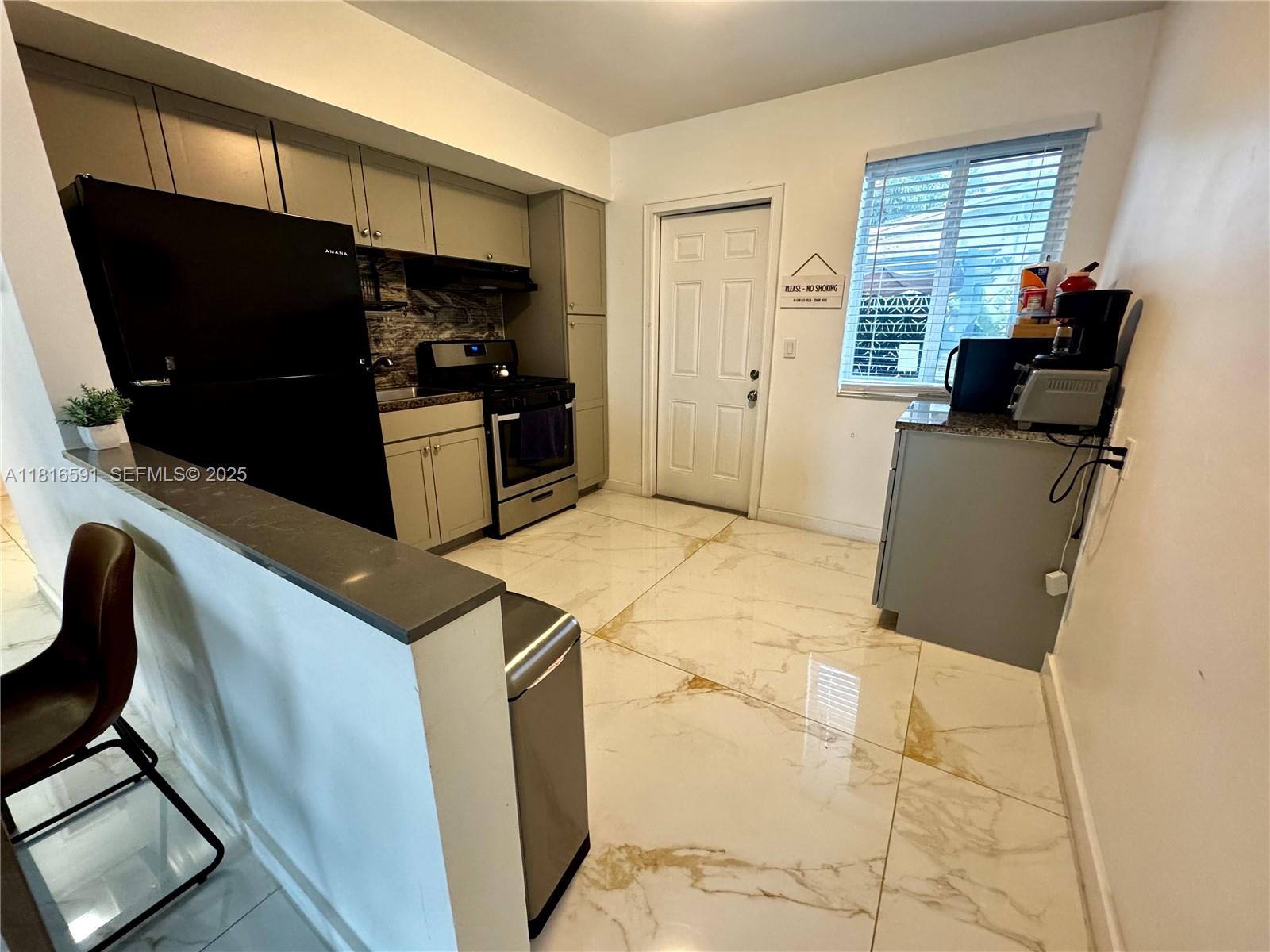 1012 Southwest 3rd Avenue Hallandale Beach, FL 33009 - Photo 26 of 35 a kitchen with a refrigerator and microwave
