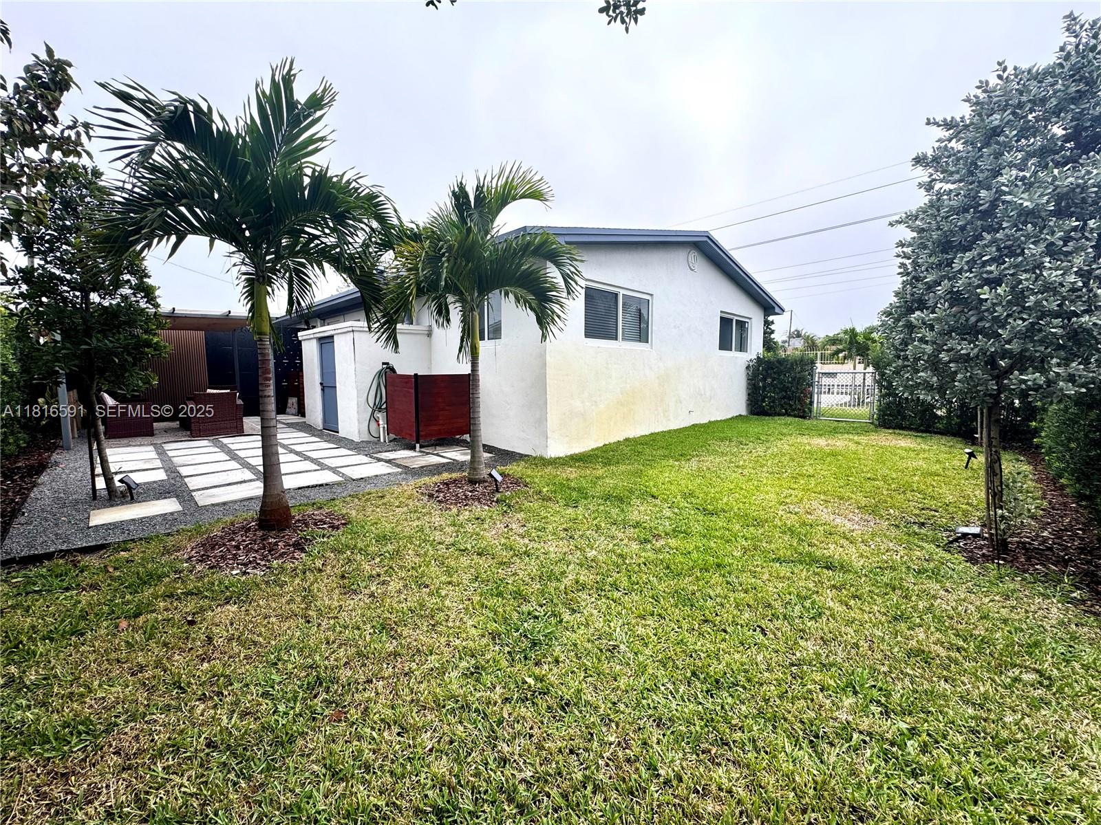 1012 Southwest 3rd Avenue Hallandale Beach, FL 33009 - Photo 34 of 35 a white house that has a tree in front of it
