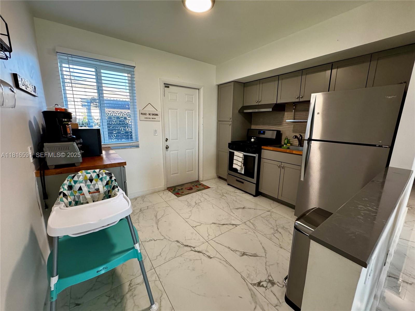1012 Southwest 3rd Avenue Hallandale Beach, FL 33009 - Photo 8 of 35 a kitchen with a refrigerator and a stove top oven