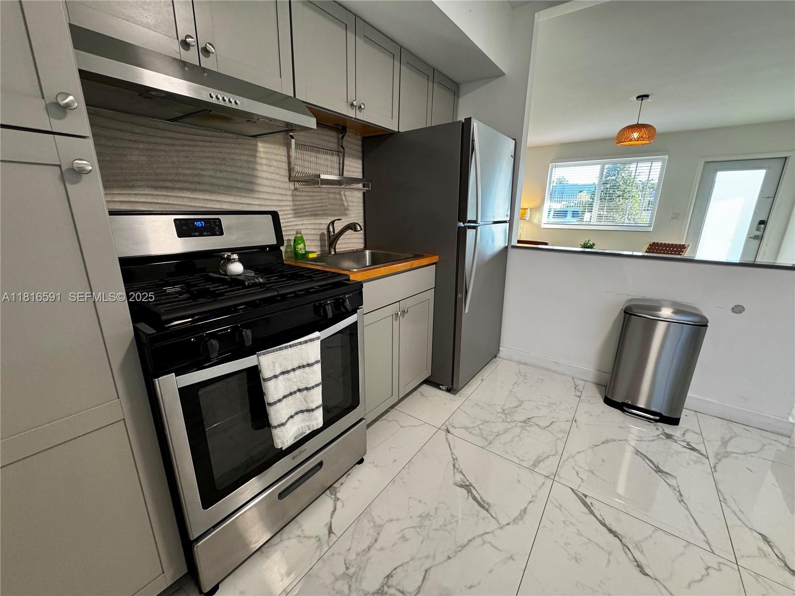 1012 Southwest 3rd Avenue Hallandale Beach, FL 33009 - Photo 10 of 35 a kitchen with stainless steel appliances granite countertop a stove a refrigerator and a cabinets