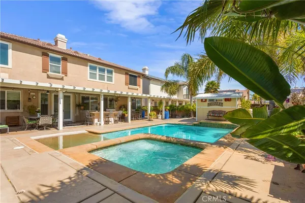 a view of a house with pool and sitting area