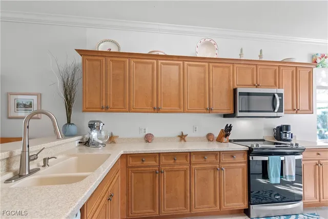 a kitchen with stainless steel appliances granite countertop a sink dishwasher stove and cabinets with wooden floor