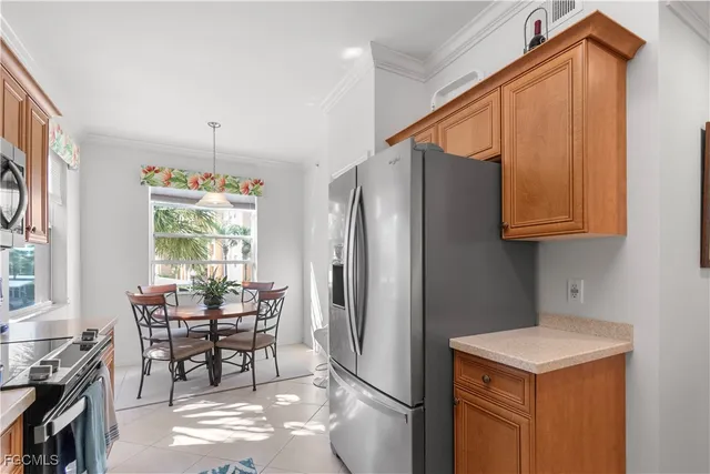 a kitchen with stainless steel appliances granite countertop a table chairs and a refrigerator