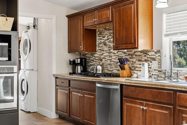 327 North Lodge Road Central, UT 84722 - Photo 13 of 45 Kitchen featuring wood-finish cabinetry, a patterned tile backsplash, and light-toned countertops
