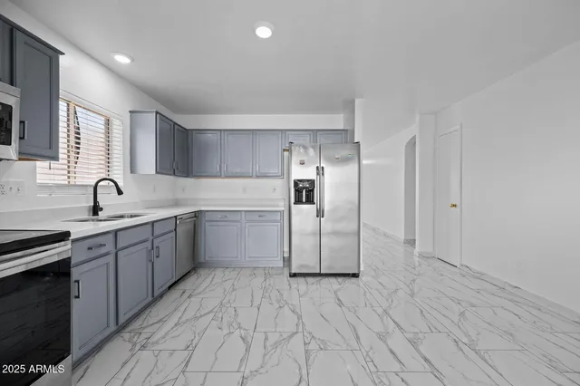 a kitchen with a sink cabinets and stainless steel appliances
