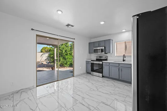 a large white kitchen with a sink stainless steel appliances and cabinets