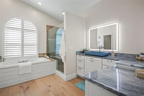 a spacious bedroom with a bed and a chandelier