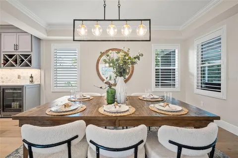 a kitchen with stainless steel appliances granite countertop a sink a stove a refrigerator cabinets and a dining table