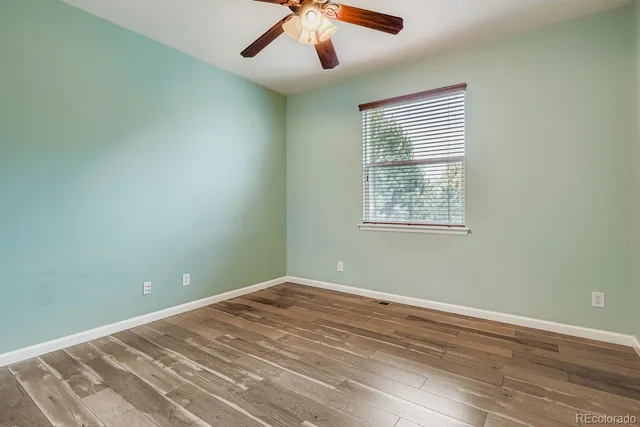 an empty room with a window and a fan