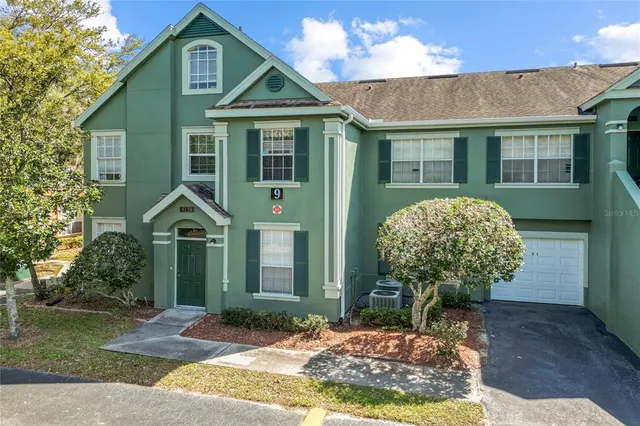 an aerial view of a house with garden space and lake view in back