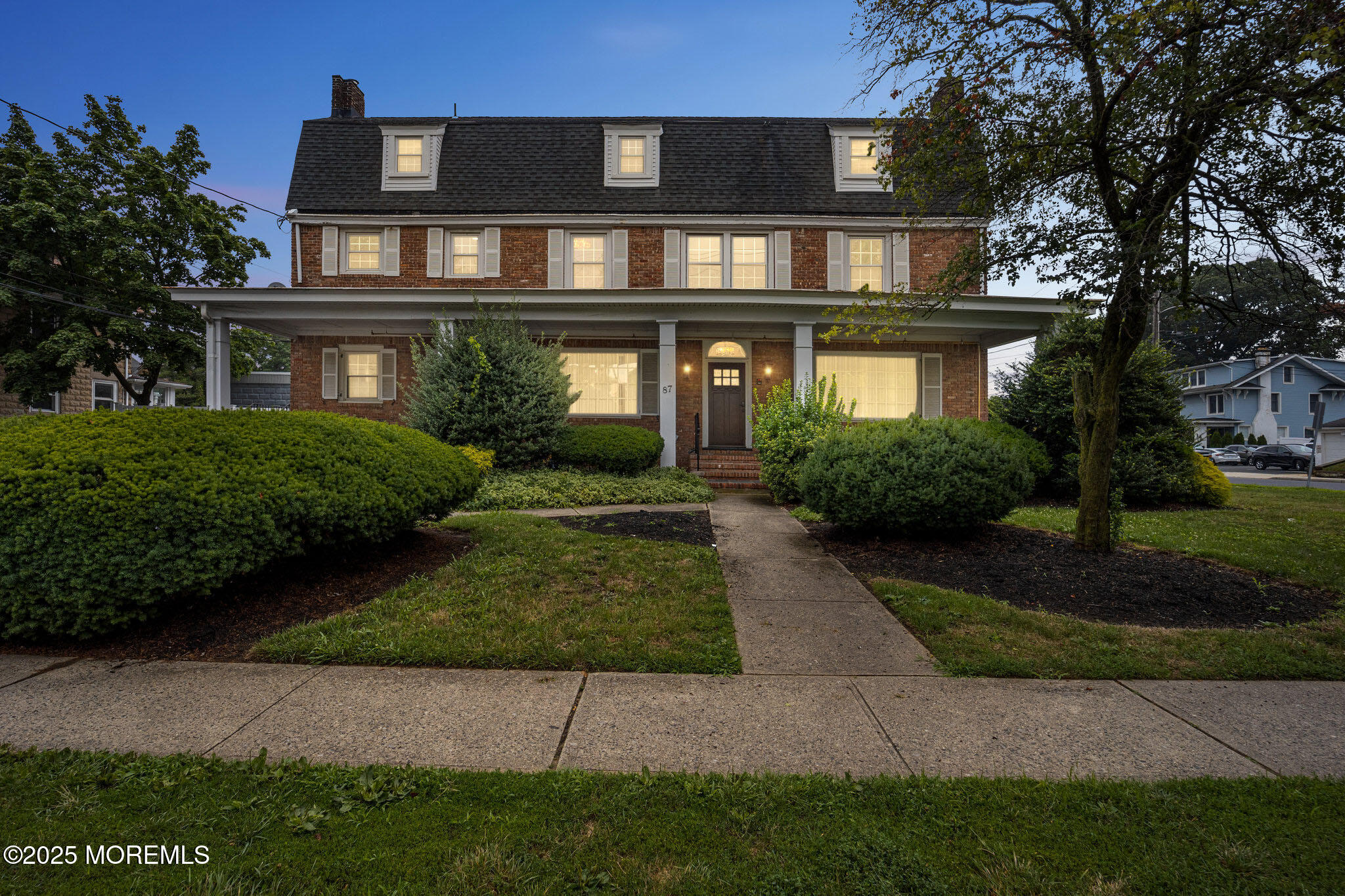 a front view of a house with a yard and potted plants