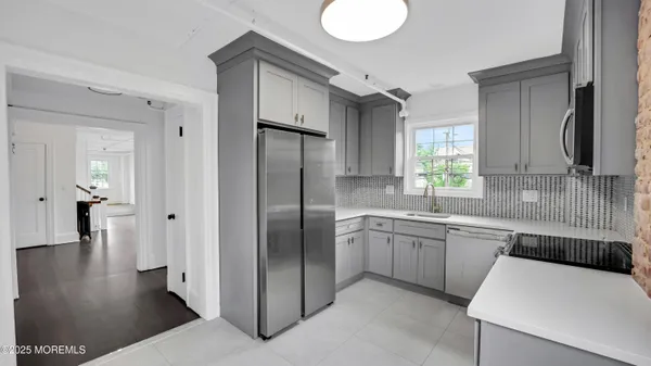 a kitchen with stainless steel appliances granite countertop a sink and a refrigerator