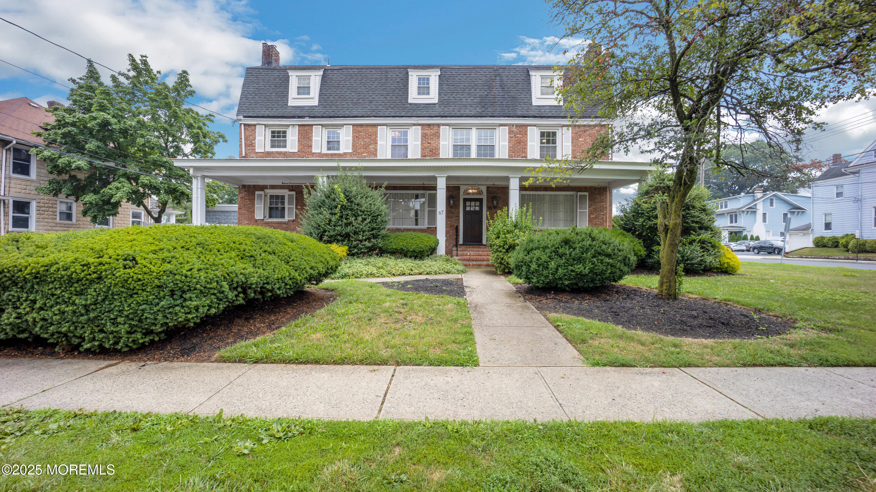 87 Maple Avenue, Unit 2 Red Bank, NJ 07701 - Photo 27 of 28 a view of a white house with a yard and plants