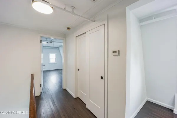 a view of a hallway with wooden floor