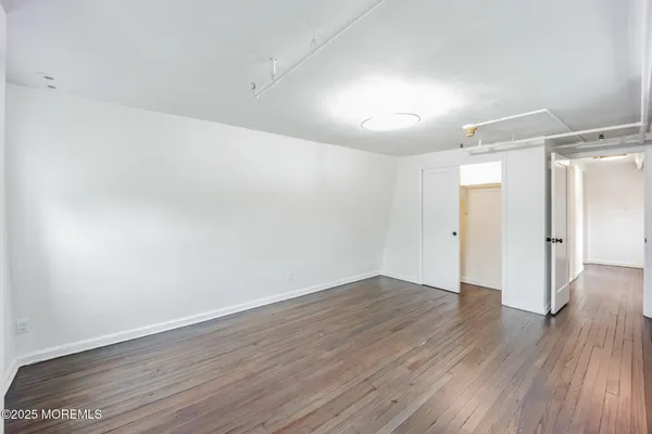 a view of an empty room with wooden floor
