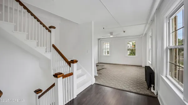 a view of hallway with stairs and wooden floor