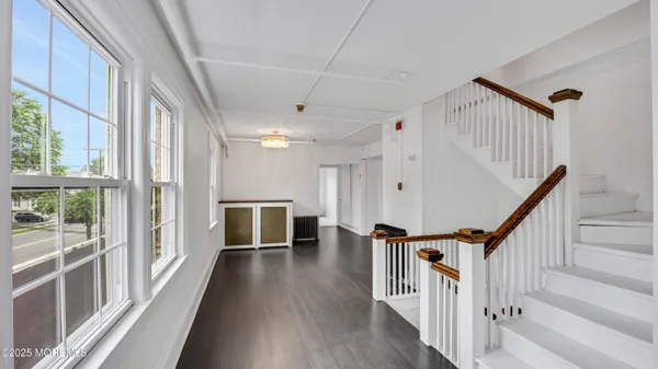 a view of an entryway with wooden floor and livingroom