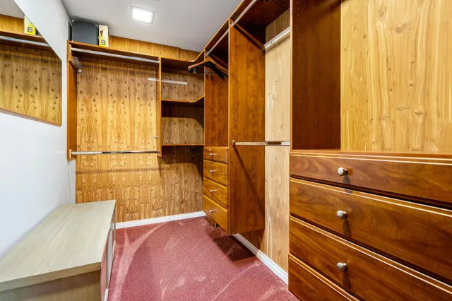 a view of walk in closet with empty racks