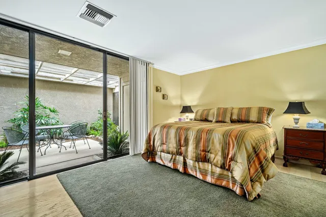 a spacious bedroom with a bed and glass door