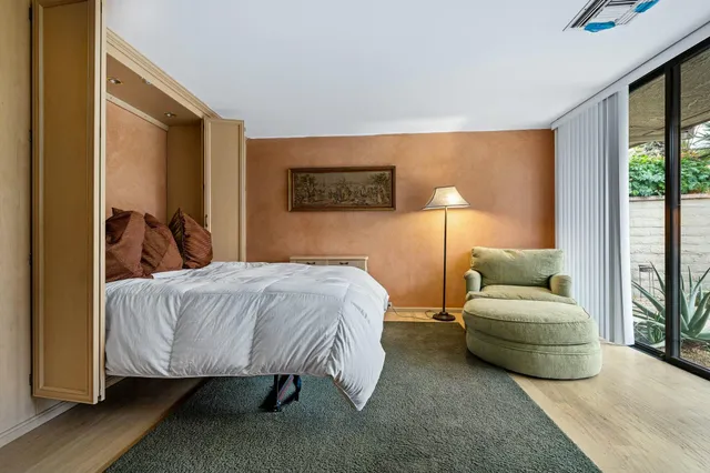 a bedroom with a bed and large windows