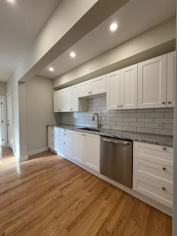 a kitchen with granite countertop a stove and cabinets