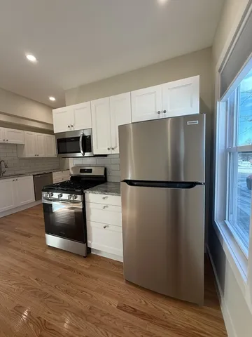 a kitchen with a refrigerator and a stove top oven