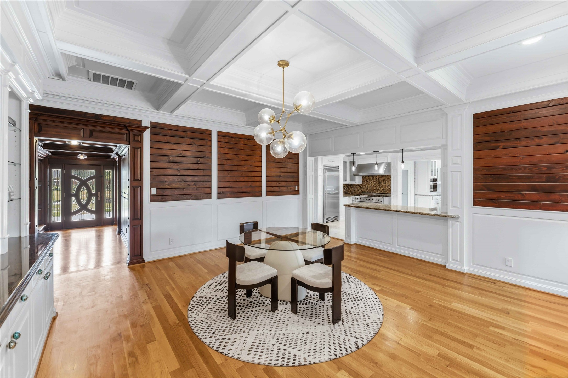 4031 Fernwood Drive Houston, TX 77021 - Photo 7 of 34 a dining room with wooden floor a chandelier a glass table and chairs