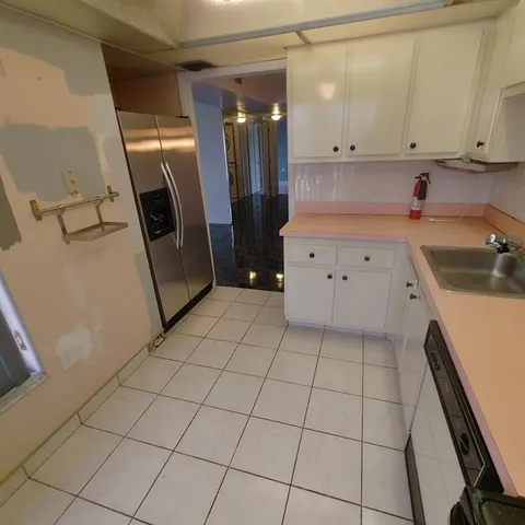 a kitchen with a sink a refrigerator and cabinets