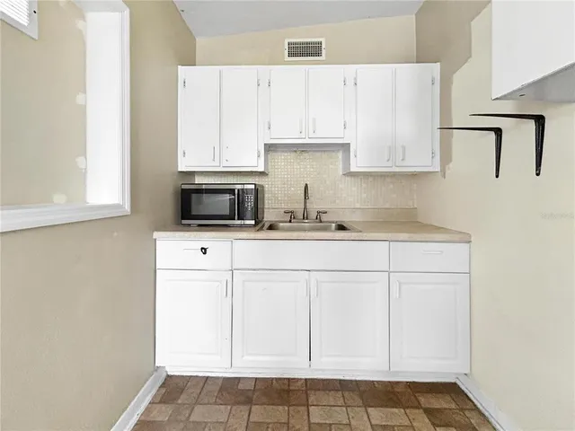a kitchen with white cabinets and white appliances