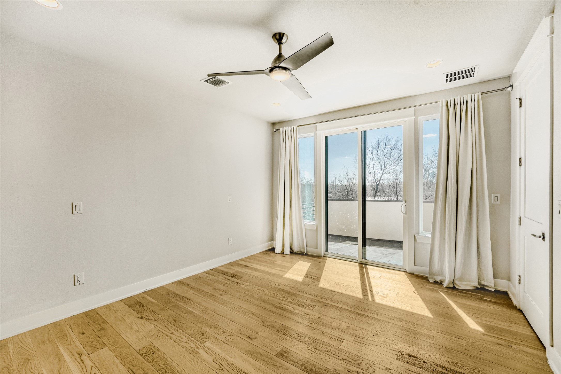 5002 Pecan Springs Road, Unit 6 Austin, TX 78723 - Photo 19 of 29 a view of empty room with wooden floor and fan