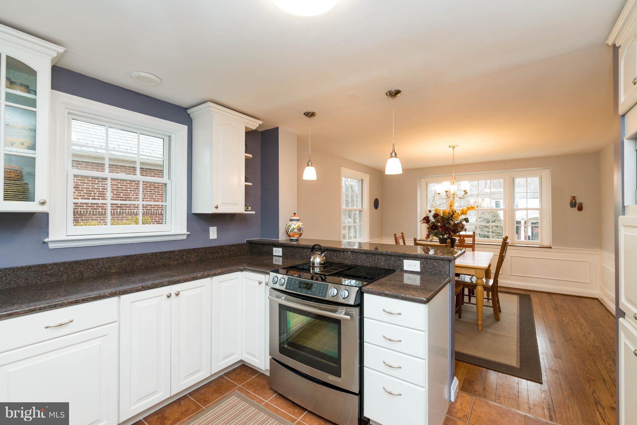 624 Wilton Road Baltimore, MD 21286 - Photo 10 of 30 a kitchen with a stove a sink a refrigerator and white cabinets with wooden floor