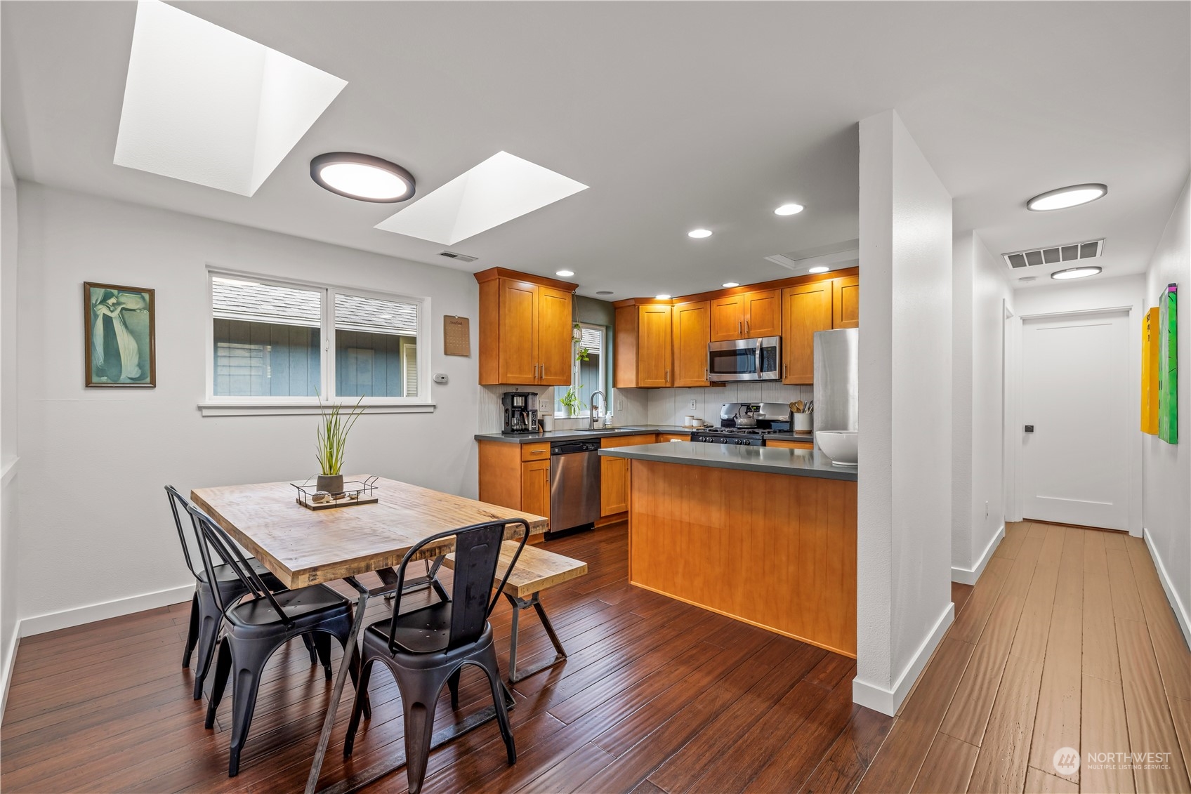 2847 Southwest Dakota Street Seattle, WA 98126 - Photo 11 of 39 a kitchen with stainless steel appliances granite countertop a dining table chairs refrigerator and microwave