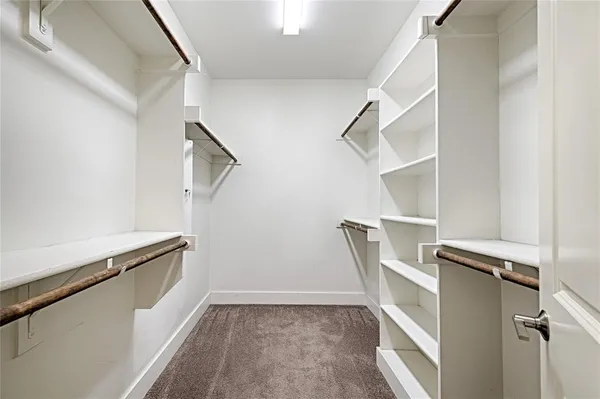 a view of walk in closet with empty racks