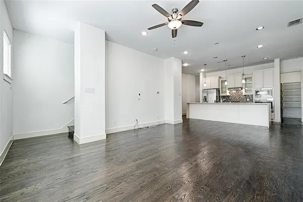 a view of a kitchen with wooden floor and a window
