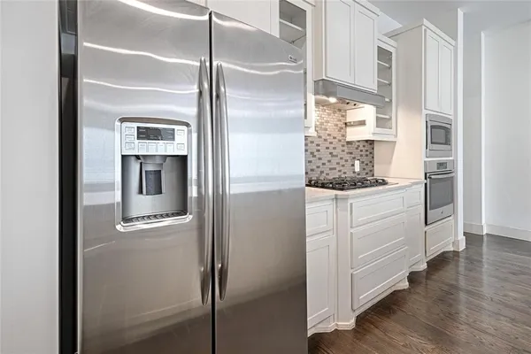 a kitchen with white cabinets and a refrigerator