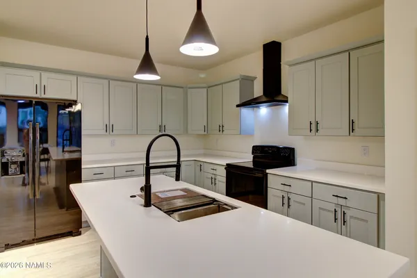 a kitchen with stainless steel appliances a stove refrigerator and cabinets